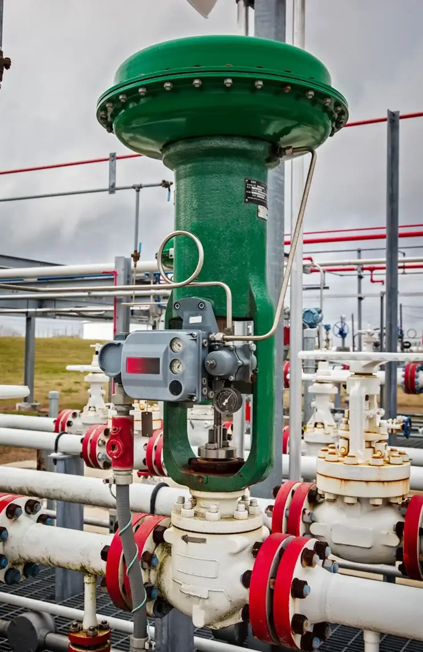 Green pneumatic fisher control valve mounted outside on a pipeline