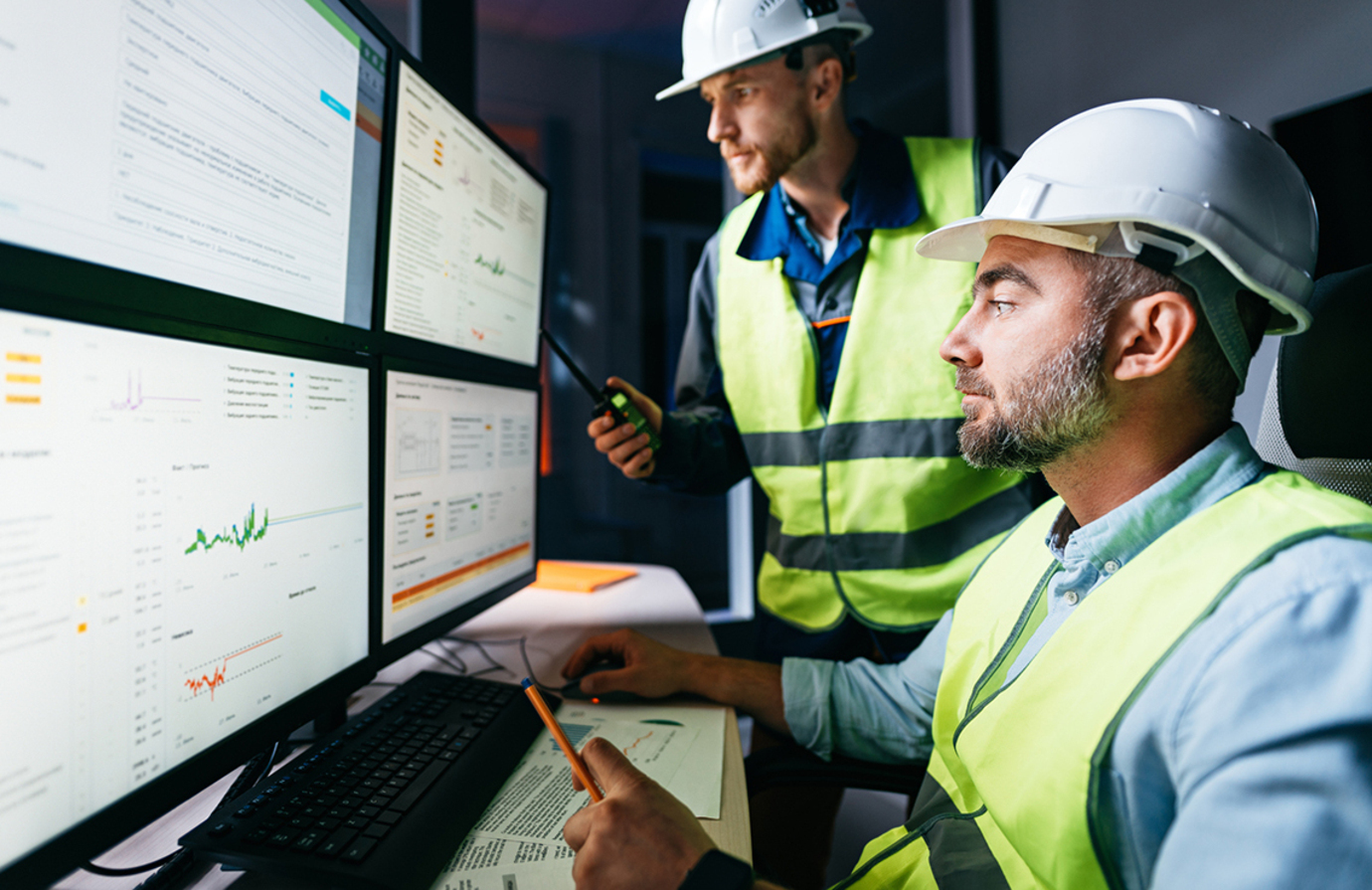 Manufacturing plant operators with hard hats in a modern control room