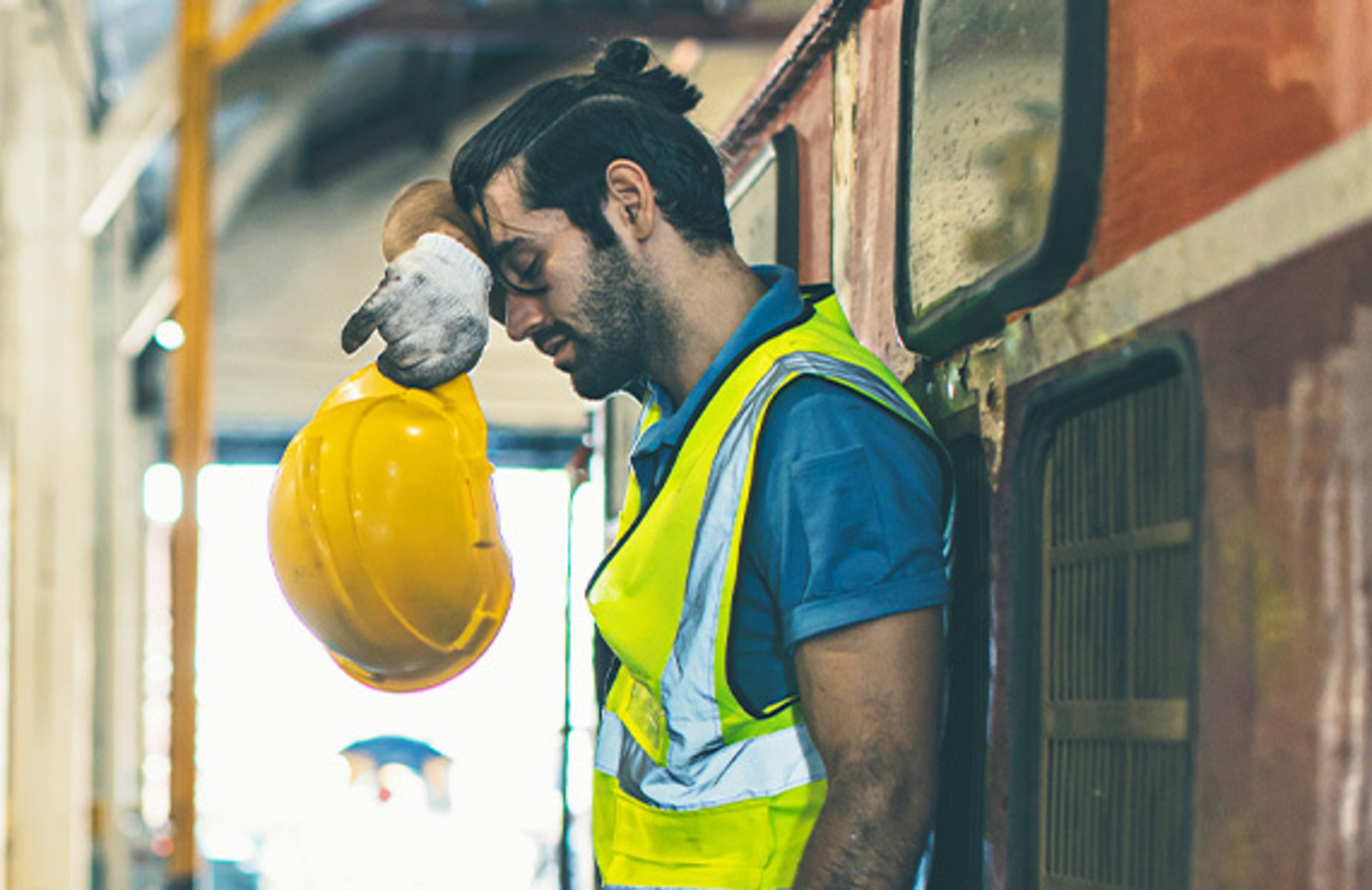 Worker in safety vest is exhausted because there are no preventative maintenance services in his factory.