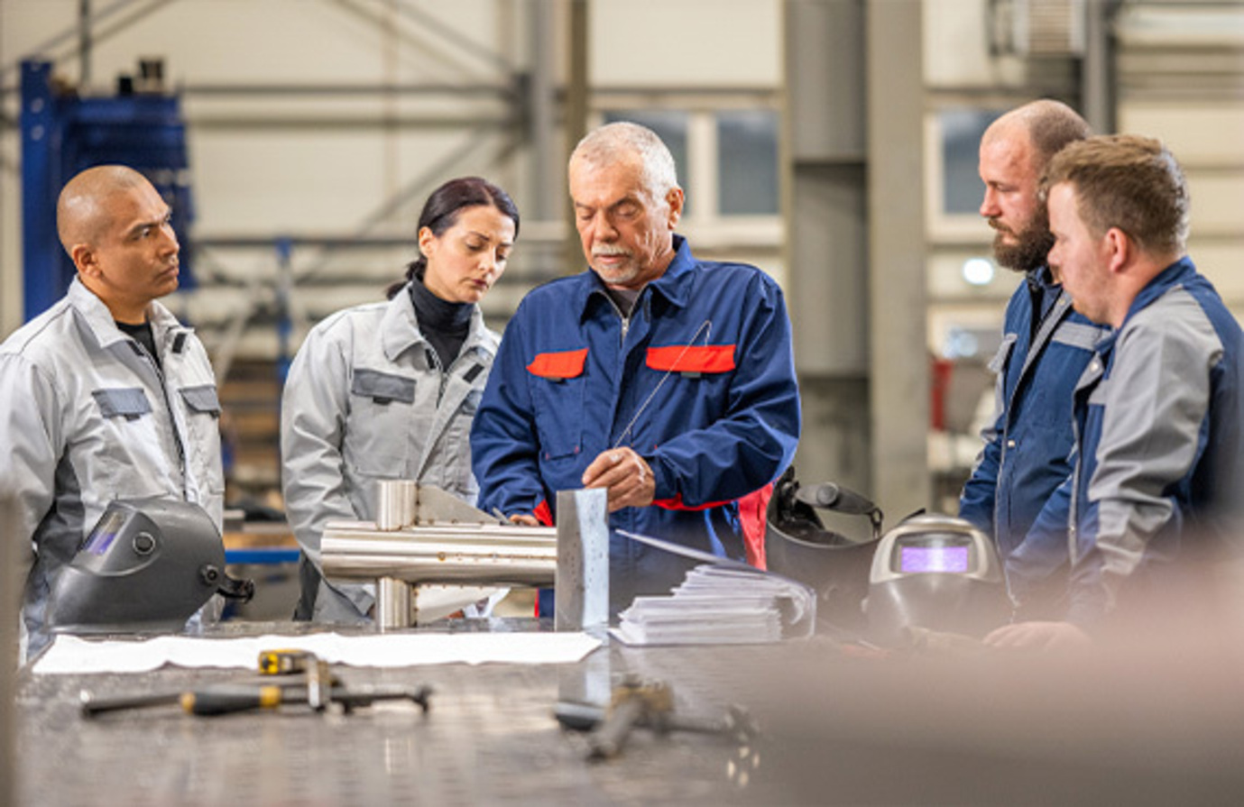 A team of factory employees participating in tailored training sessions aimed at improving manufacturing processes.