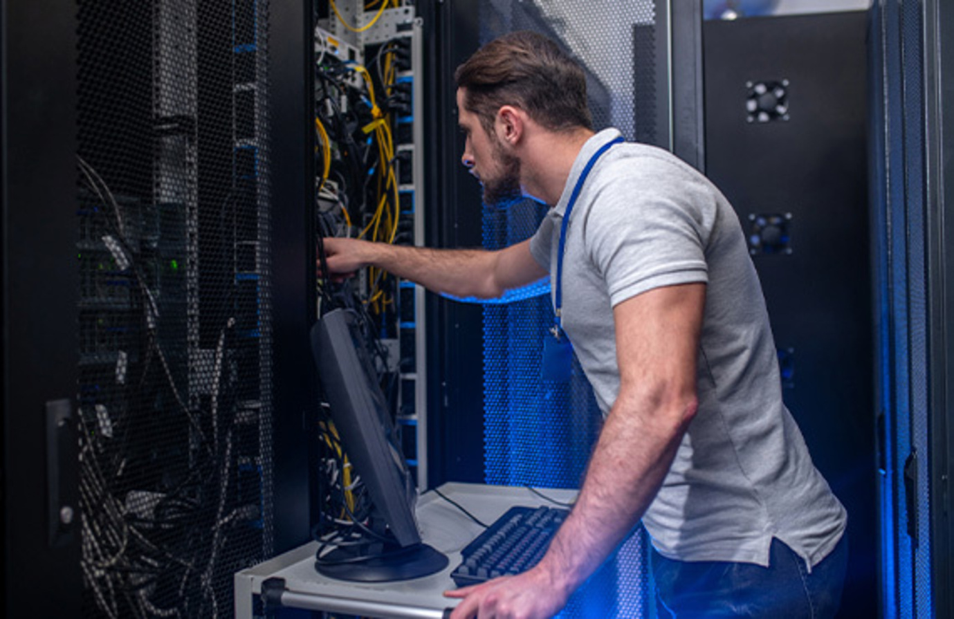 Man in a server room representing cybersecurity protection within industrial operations