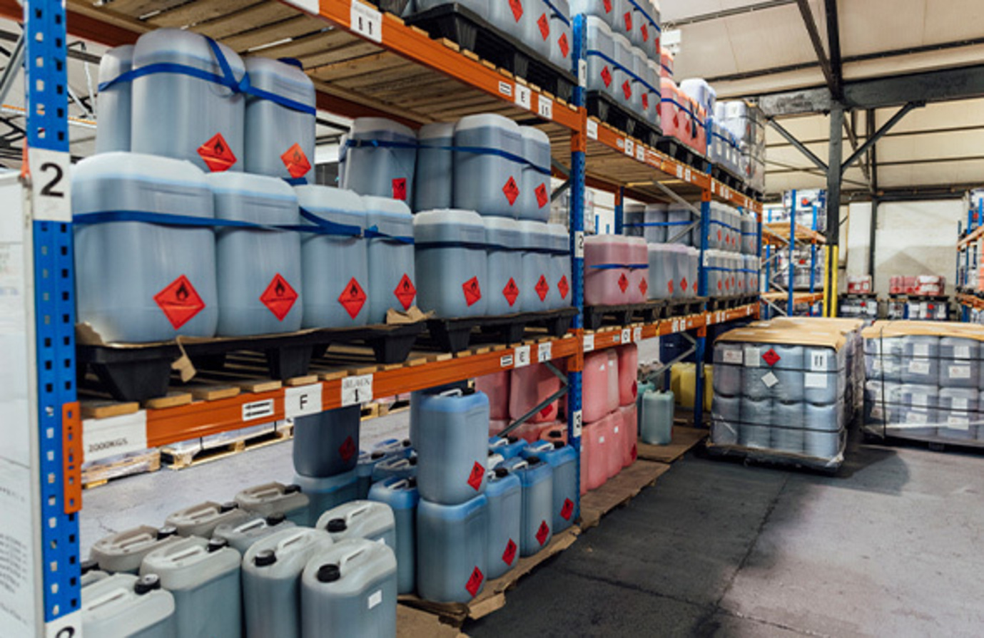 Chemical barrels on storage shelving, emphasizing the need for proper cybersecurity in a chemical plant facility.