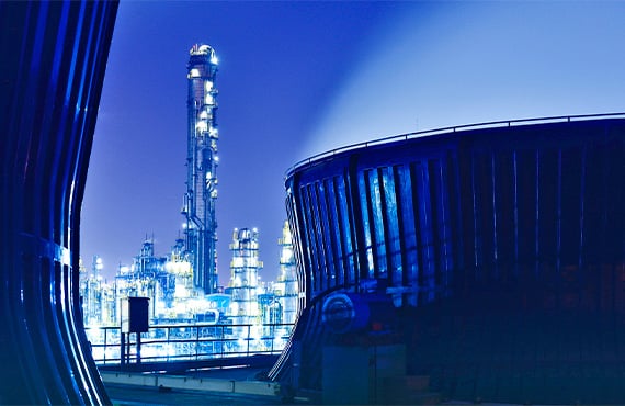 IIoT asset management at work in a large crude oil refinery at night.