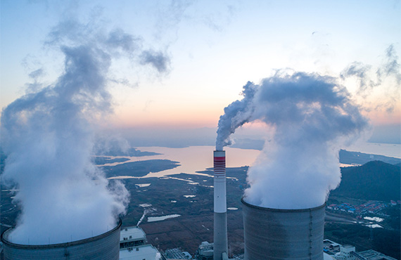 Smoke billows from an industrial plant, emphasizing the need for robust cybersecurity in steam power operations.