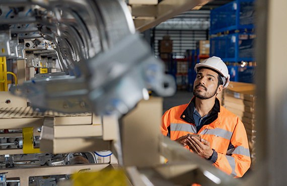 An employee in an industrial factory collecting data.
