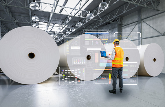 Man with laptop in a paper mill using advanced process control system.