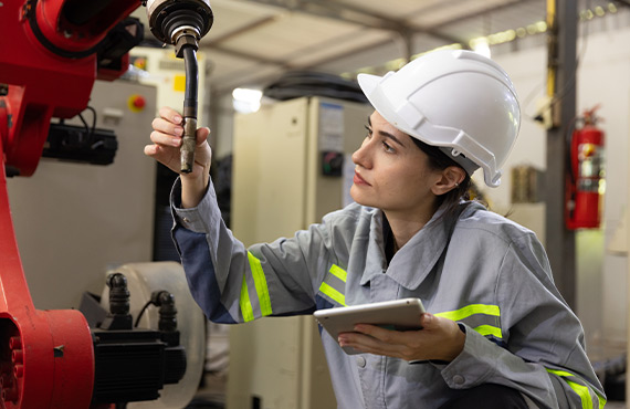 An Industry 4.0 representation with a female worker examining the machine