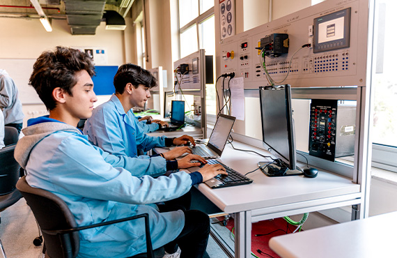 Two employees training in a control room, safeguarding process automation from cyber risks.