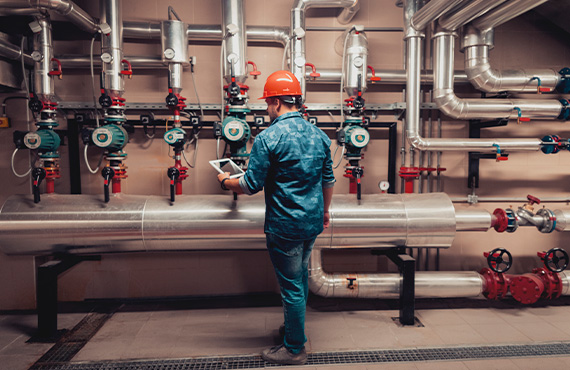 Male worker conducting preventative maintenance, examining valves and actuators.