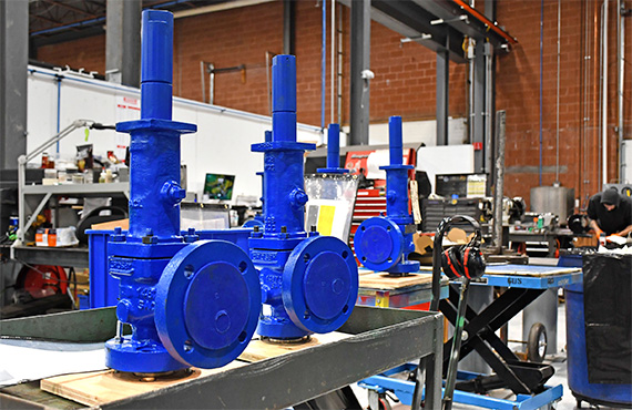 Two blue Crosby Pressure Relief Valves in a valve repair facility.