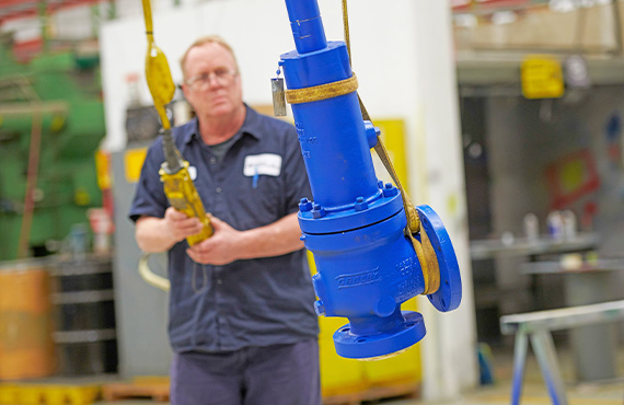 A pressure relief valve (PRV) being lifted in a facility for installation.