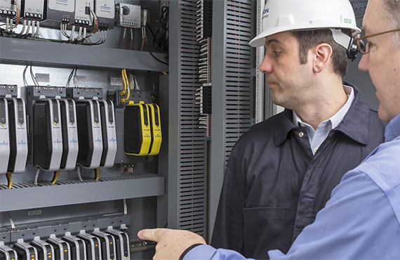Systems engineers inspecting a DeltaV distributed control system