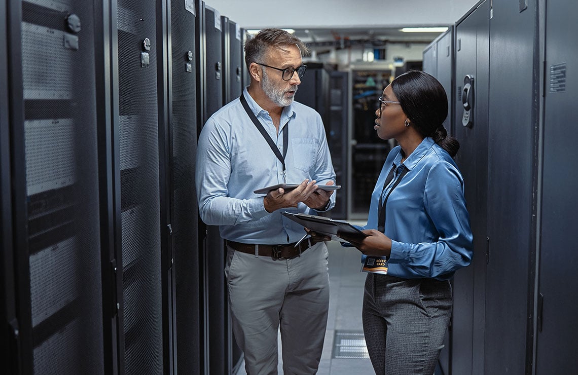 Plant engineers discussing OT cybersecurity in a server room