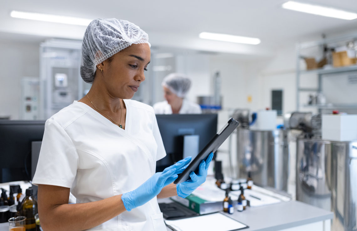 Scientist in a life sciences manufacturing facility on a tablet