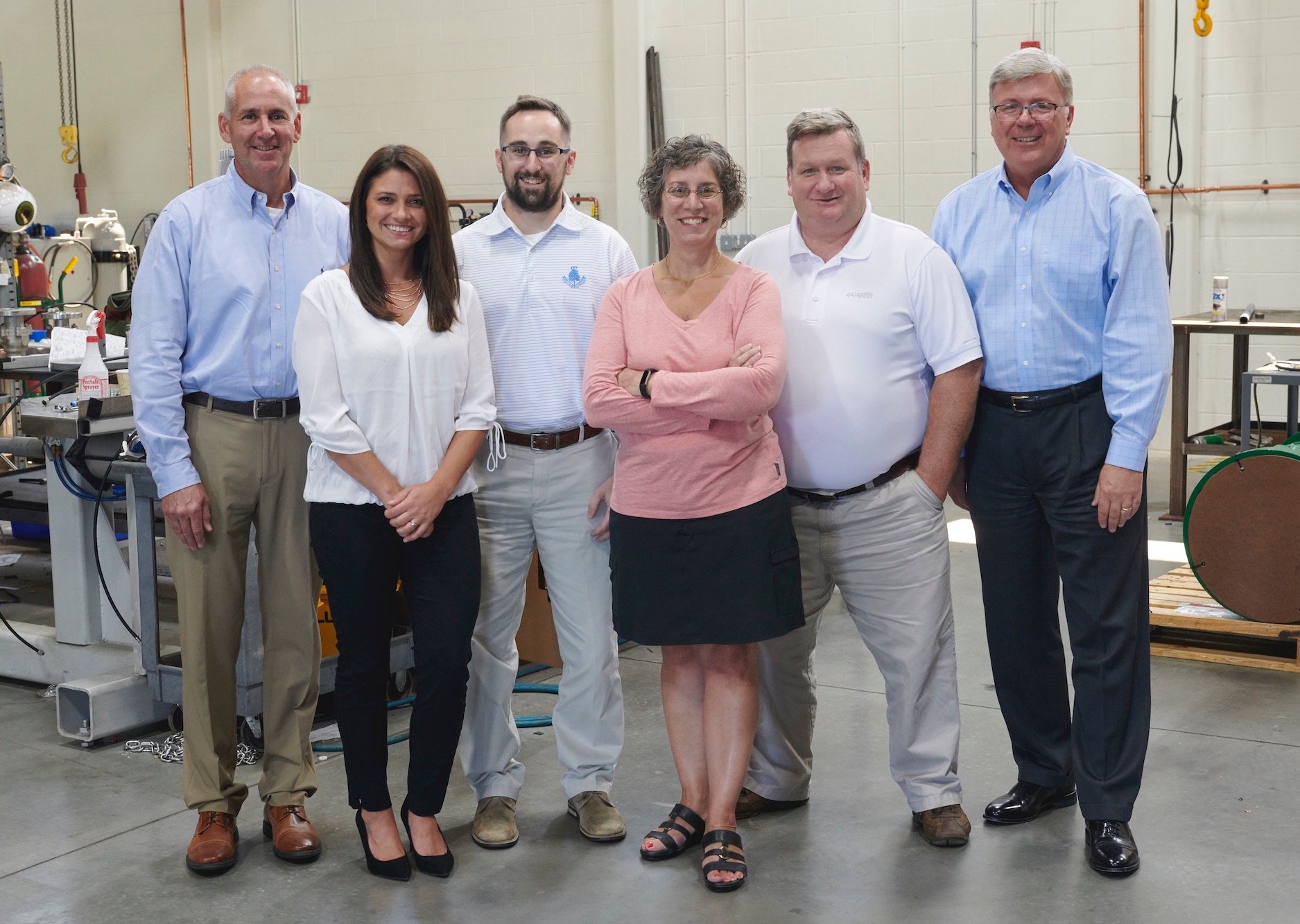 Join the Proconex Team! Image shows a group of six smiling Proconex isolation valve team employees in business-casual clothing in a professional setting