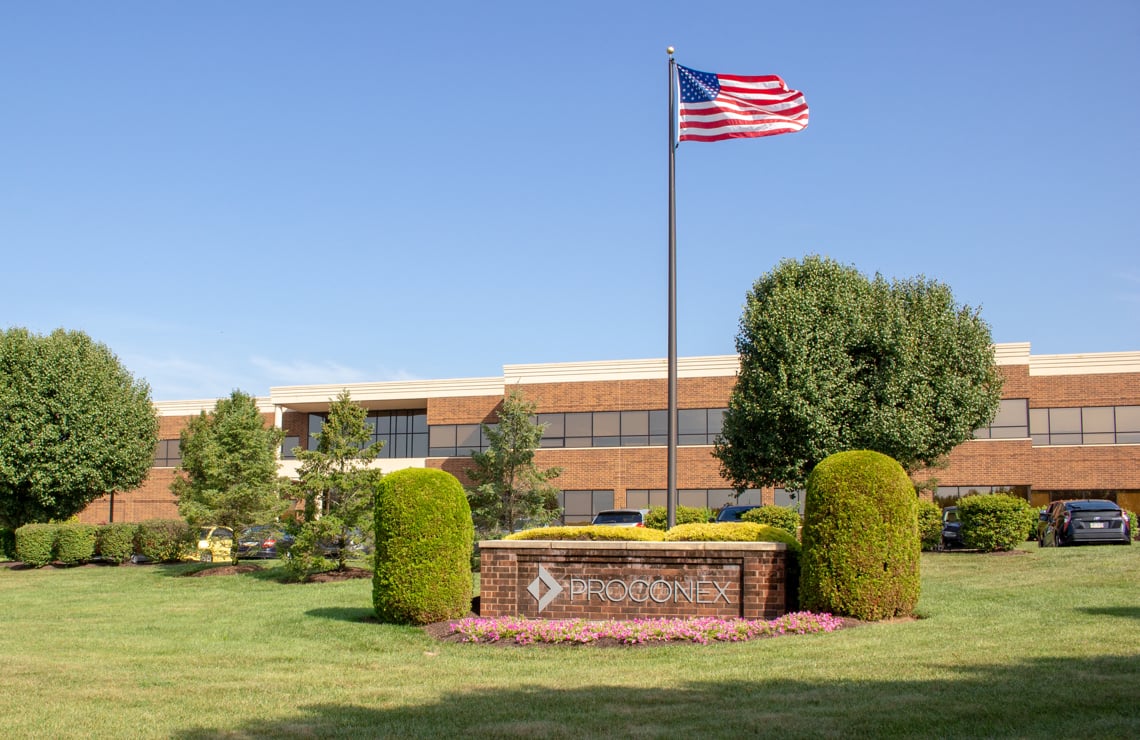 Proconex Building in Royersford, PA Image shows a brick office building with "PROCONEX" signage, an American flag, and landscaping under a blue sky.