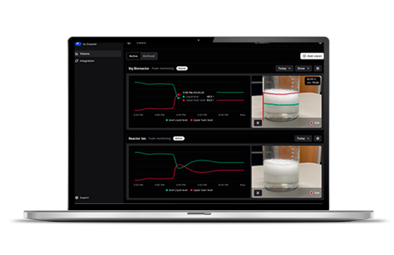 A laptop displaying a dashboard monitoring bioreactors with graphs and video feeds.