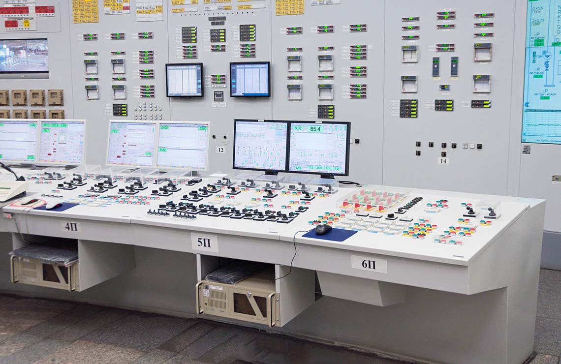 Image shows the interior shot of control room of a nuclear energy power plant 